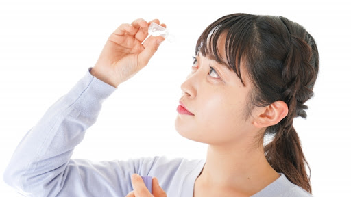 目薬をつけている女性